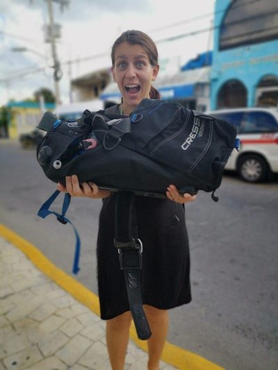 Holding diving equipment packed in a "taco roll" (our first scuba diving in Cozumel)